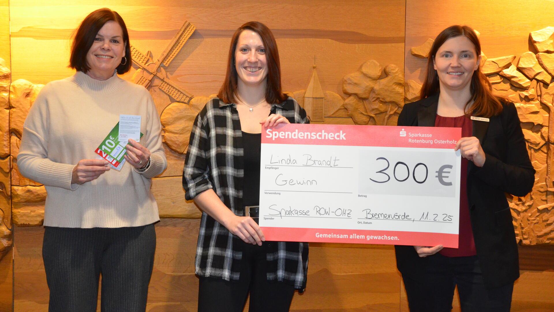 Citymanagerin Bärbel Hensel (links) und Sarah Böhnke (rechts) überreichten Linda Brandt den Hauptgewinn der Jahresverlosung des Bremervörder Einkaufsgutscheins.