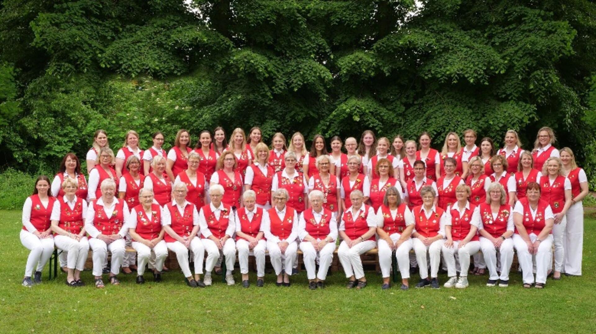 Gruppenbild von Frauen in weißen Hosen und roten Westen.