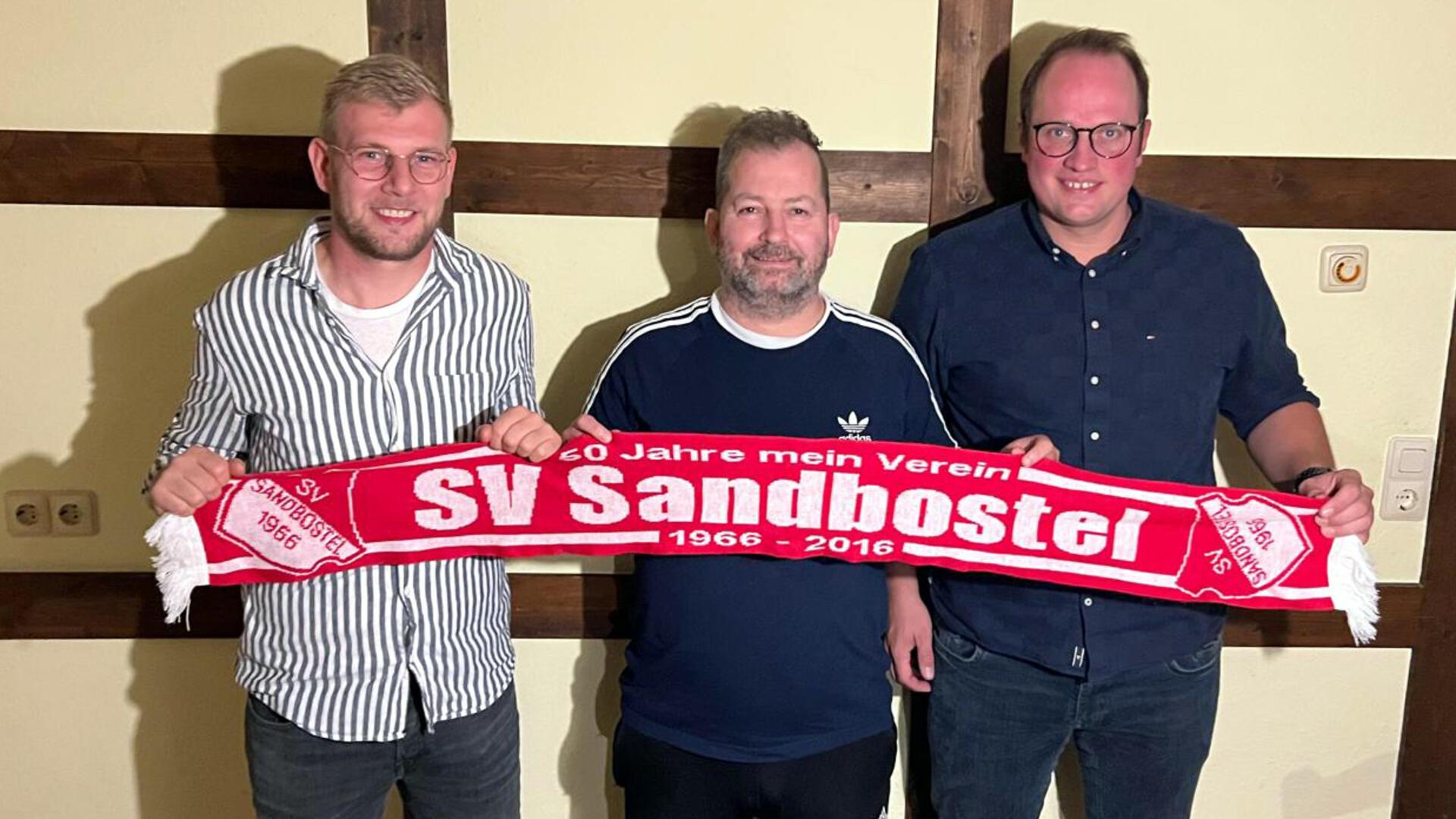Daniel Ariens (Mitte) kehrt nach zwei Jahren Pause auf die Trainerbank zurück. Sandbostels Fußball-Obmann Hendrik Schnackenberg (rechts) und sein Co Arndt Dreyer freuen sich über die Zusage.