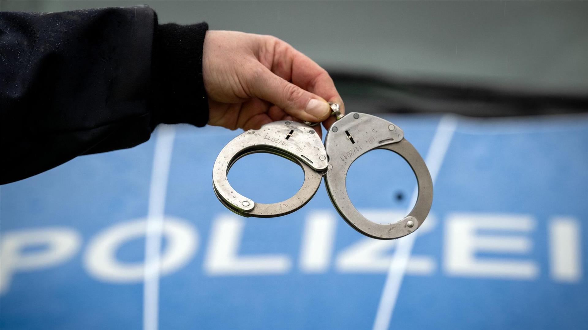 Ein Polizist hält während einer Verkehrskontrolle ein Paar Handschellen.