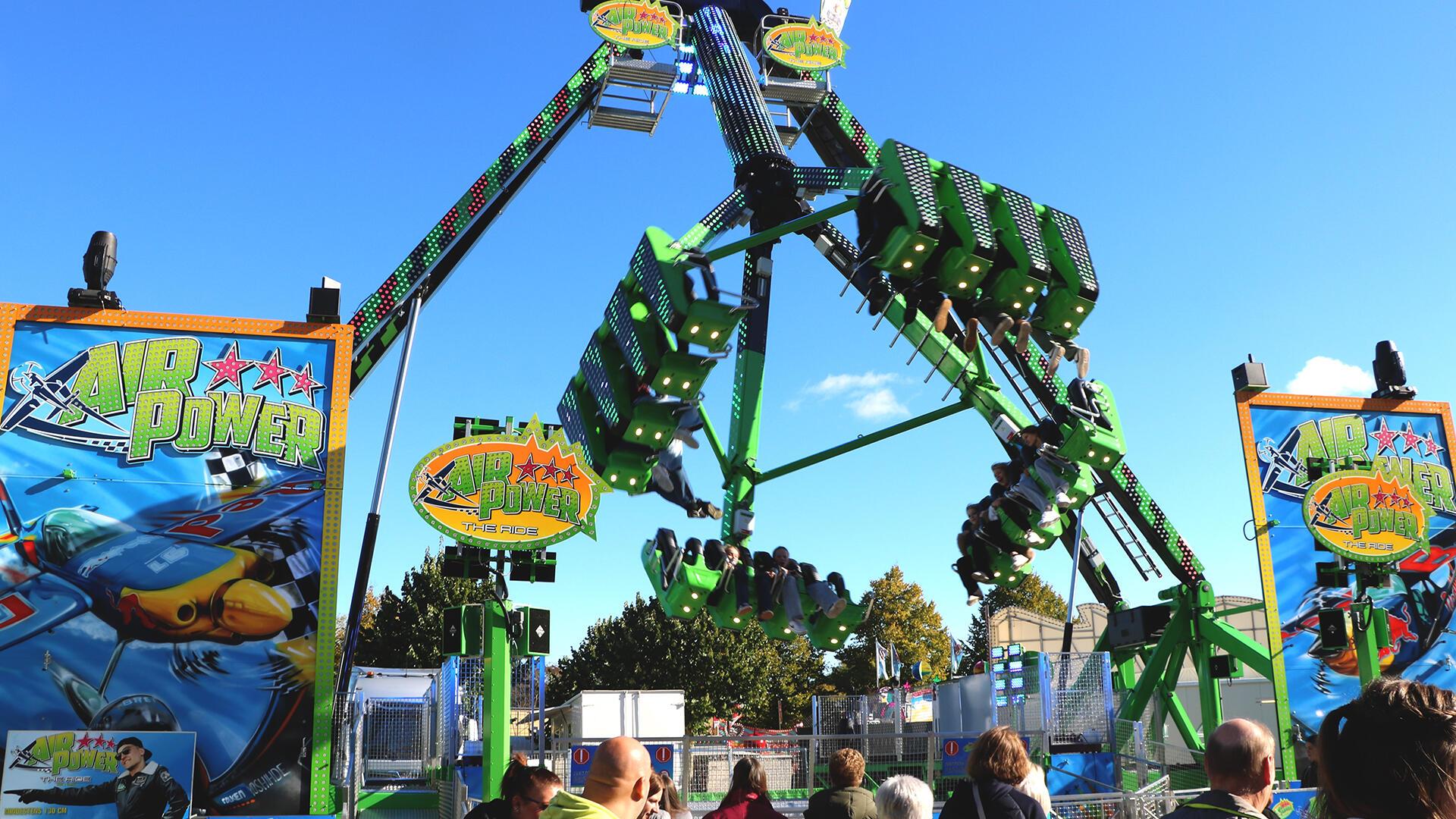 Leute stehen vor dem Fahrgeschäft "Air Power". Es ist erstmals auf dem Frühjahrsmarkt in Bremerhaven dabei. 