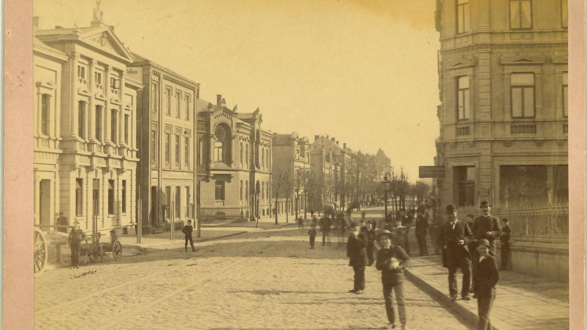 Das Foto zeigt einen Blick in die Borriesstraße um das Jahr 1900. Im zweiten Gebäude auf der linken Seite betrieben „W. Sander & Sohn“ eine fotografische Anstalt.