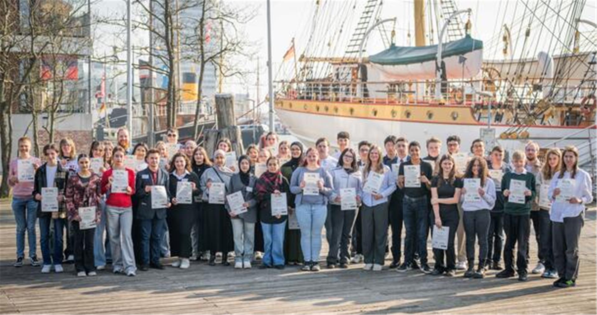 Das Gruppenfoto zeigt zahlreiche neue gewählte Mitglieder des Jugendparlaments Bremerhaven, die sich für das Foto vor der "Schulschiff Deutschland" aufgestellt haben. 
