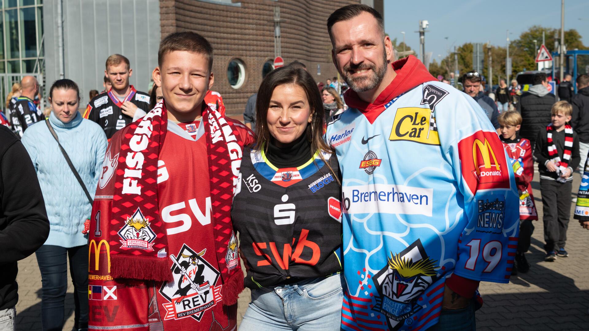 Drei Menschen in Eishockey-Trikots. 