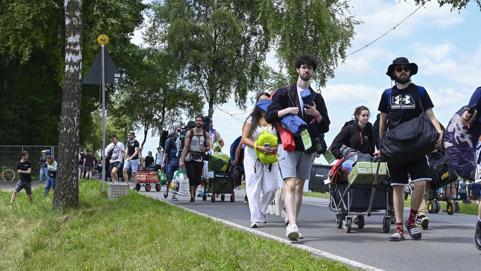 Ein Menschenmenge auf der Straße mit Rucksäcken und Bollerwagen