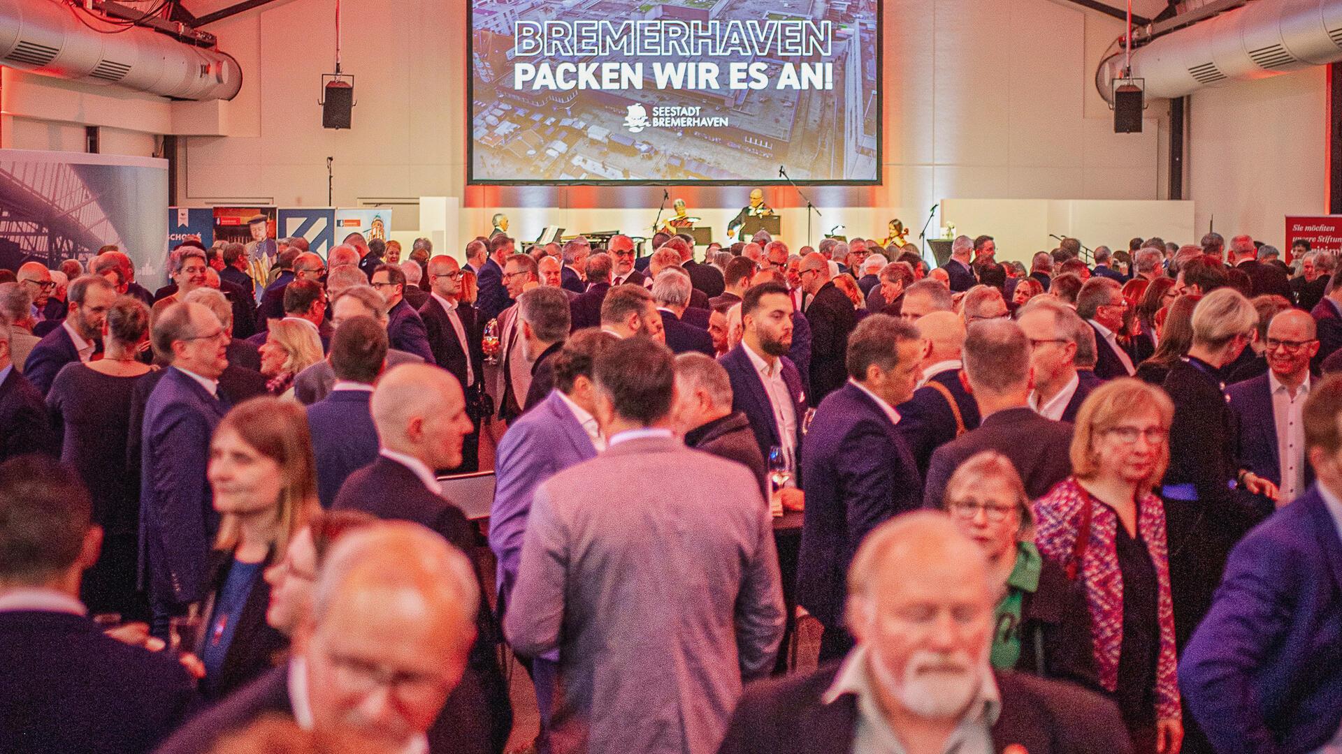 Viele Menschen in einem Saal. 