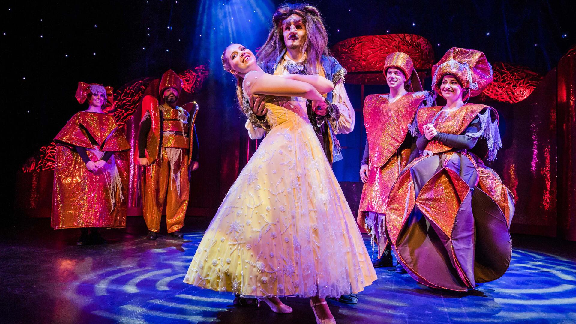 Die Hauptfiguren des Musicals „Die Schöne und das Biest“ stehen in ihren Kostümen auf einer Bühne. Das Theater Liberi führt das Stück in der Kugelbake-Halle in Cuxhaven auf. 