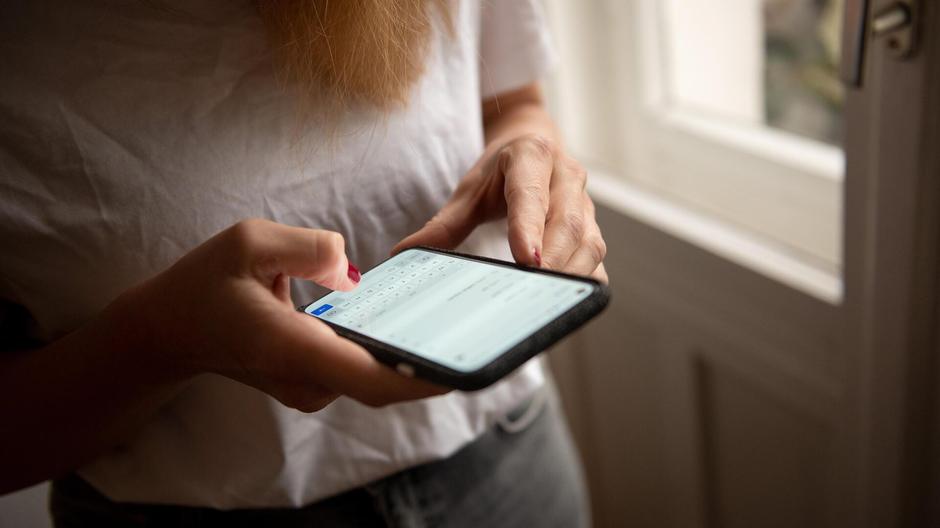 Eine Person hält ein Smartphone.