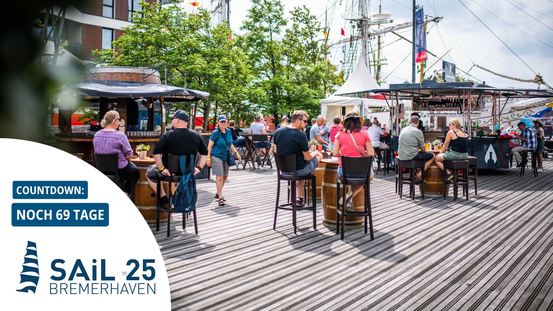 Menschen sitzen auf einem Deck am Hafen. Das Wein-Deck auf dem Lloydplatz