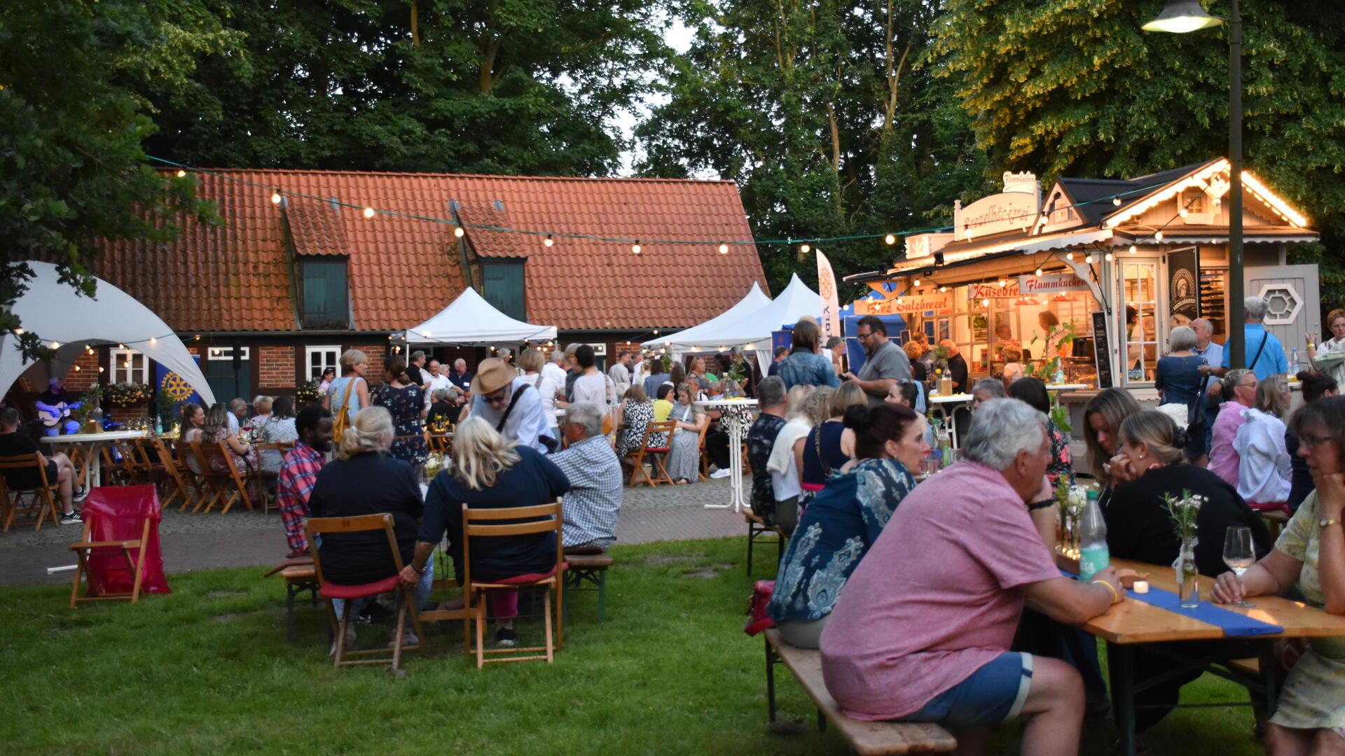 Menschen auf einem Hof zwischen Bäumen