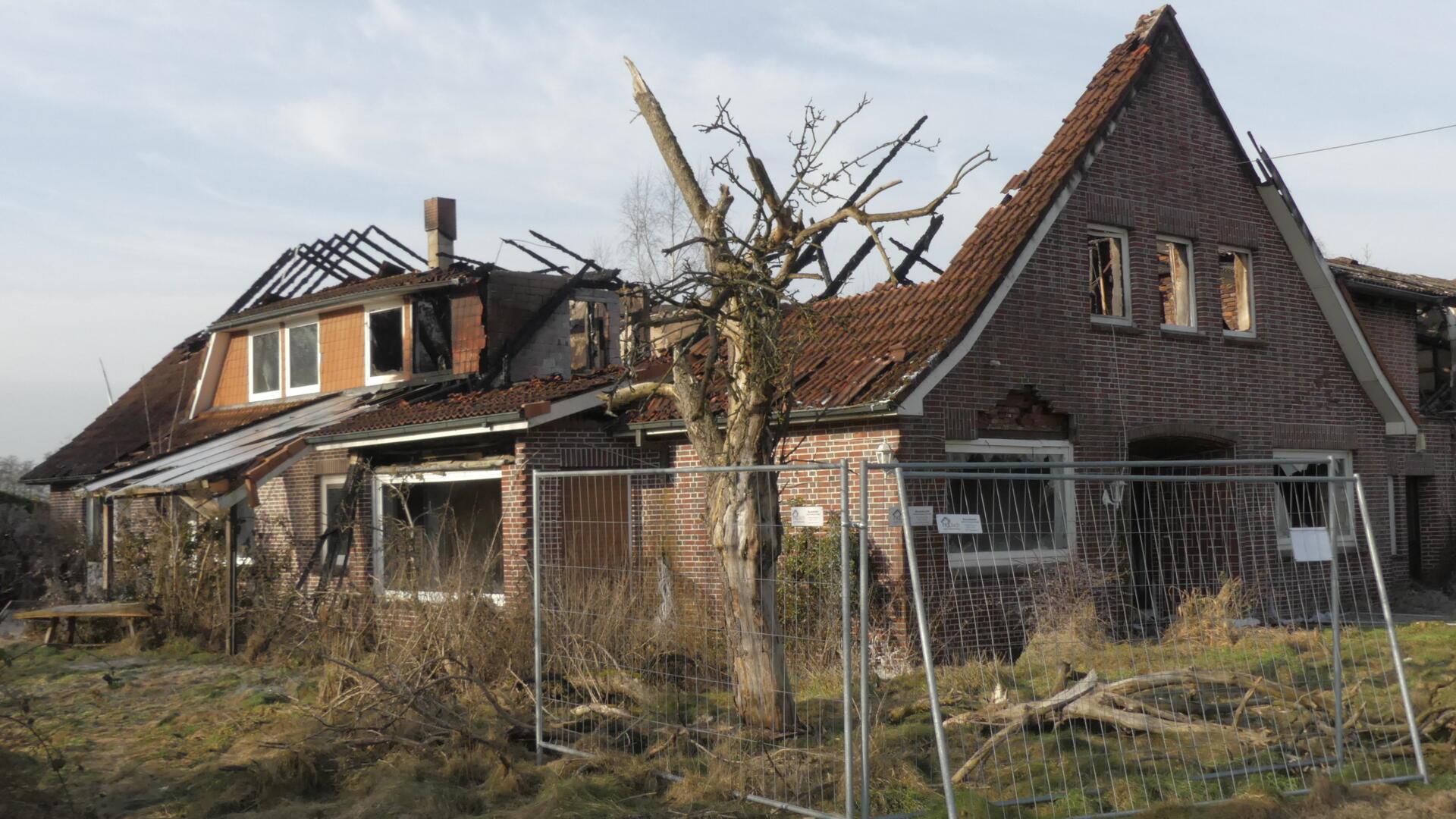 Die Ruine eines abgebrannten Wohnhauses ist mit Bauzäunen umstellt.