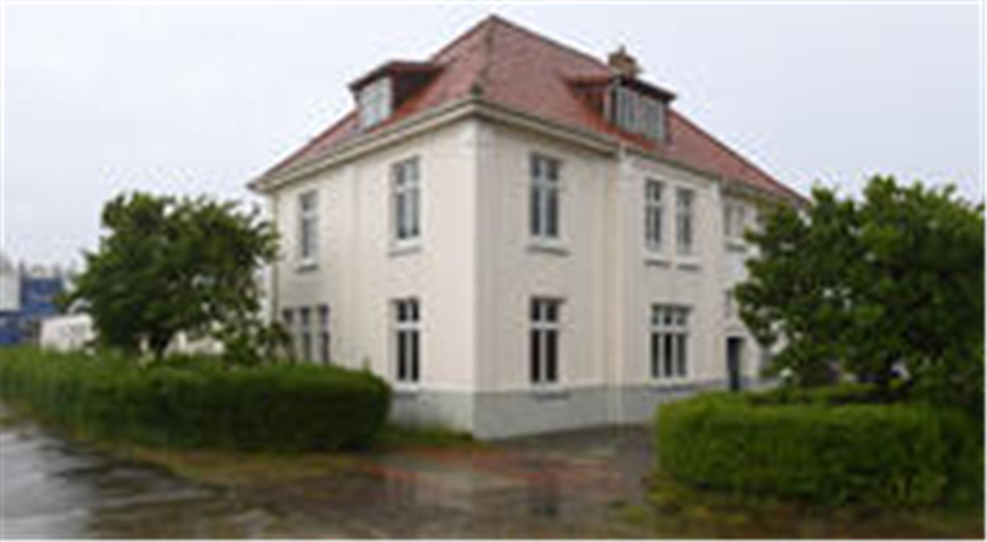 Gebäude mit Büschen und Bäumen. 