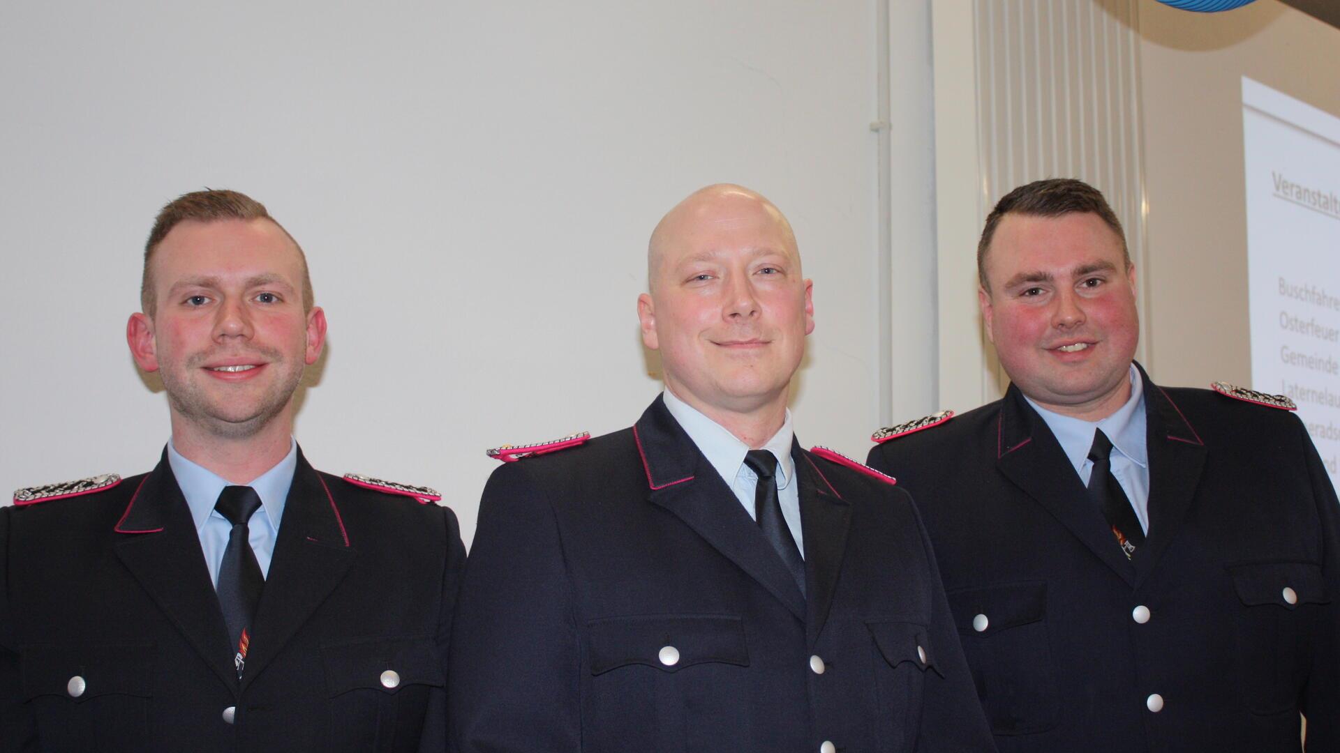 Drei Männer in Feuerwehr-Uniform schauen in die Kamera.