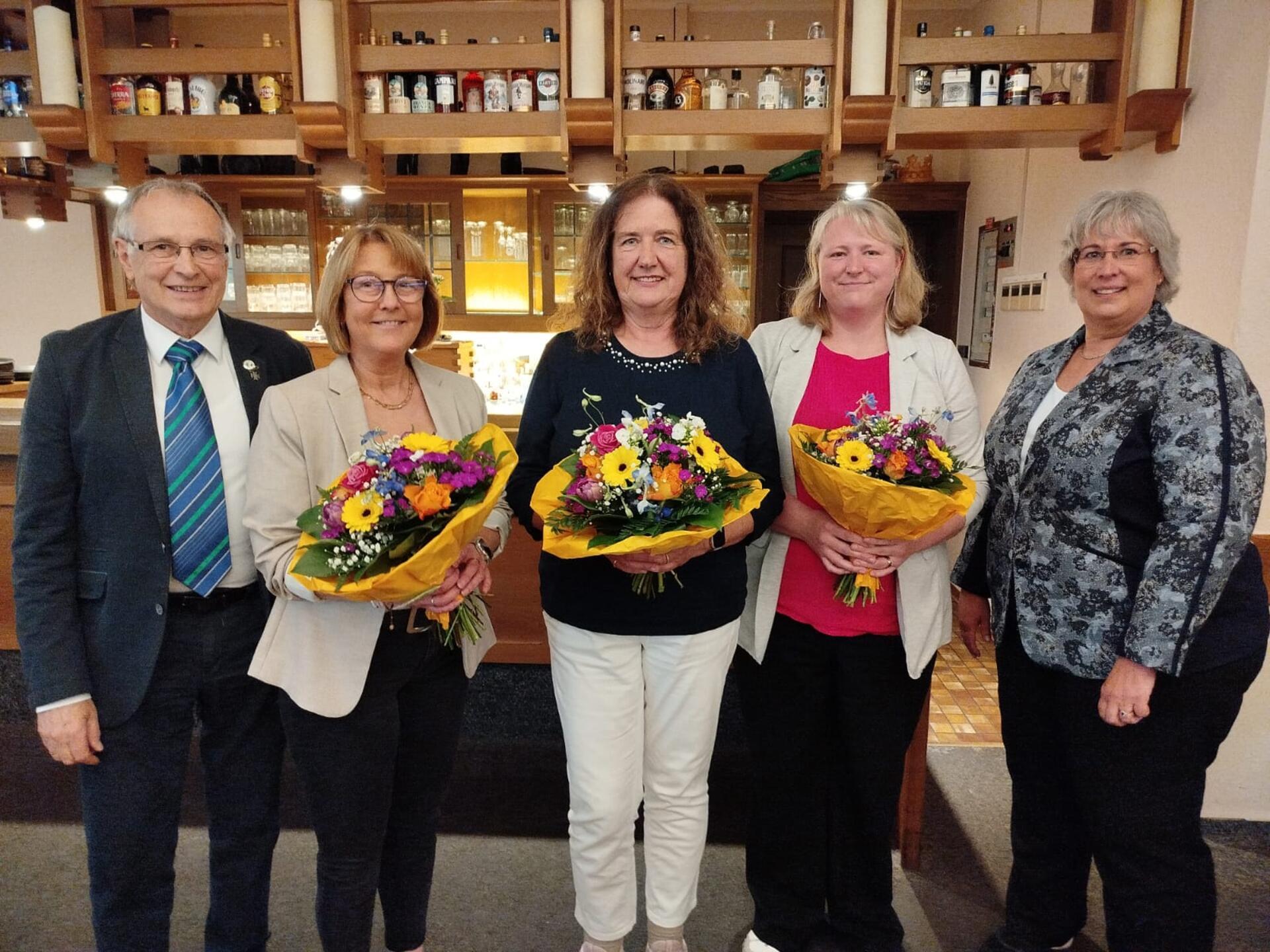 Gruppenfoto mit fünf Erwachsenen, einige halten Blumensträuße in der Hand. Das neue Leitungsteam der Arbeitsgemeinschaft (AG) Zeven der Rheuma-Liga Niedersachsen setzt sich wie folgt zusammen (von links): Georg Breitenbach, Carola Viebrock (Beisitzerin), Ulrike Benz (Teamleiterin), Anja Kieper (stellvertretende Teamleiterin) und Ante Breitenbach.