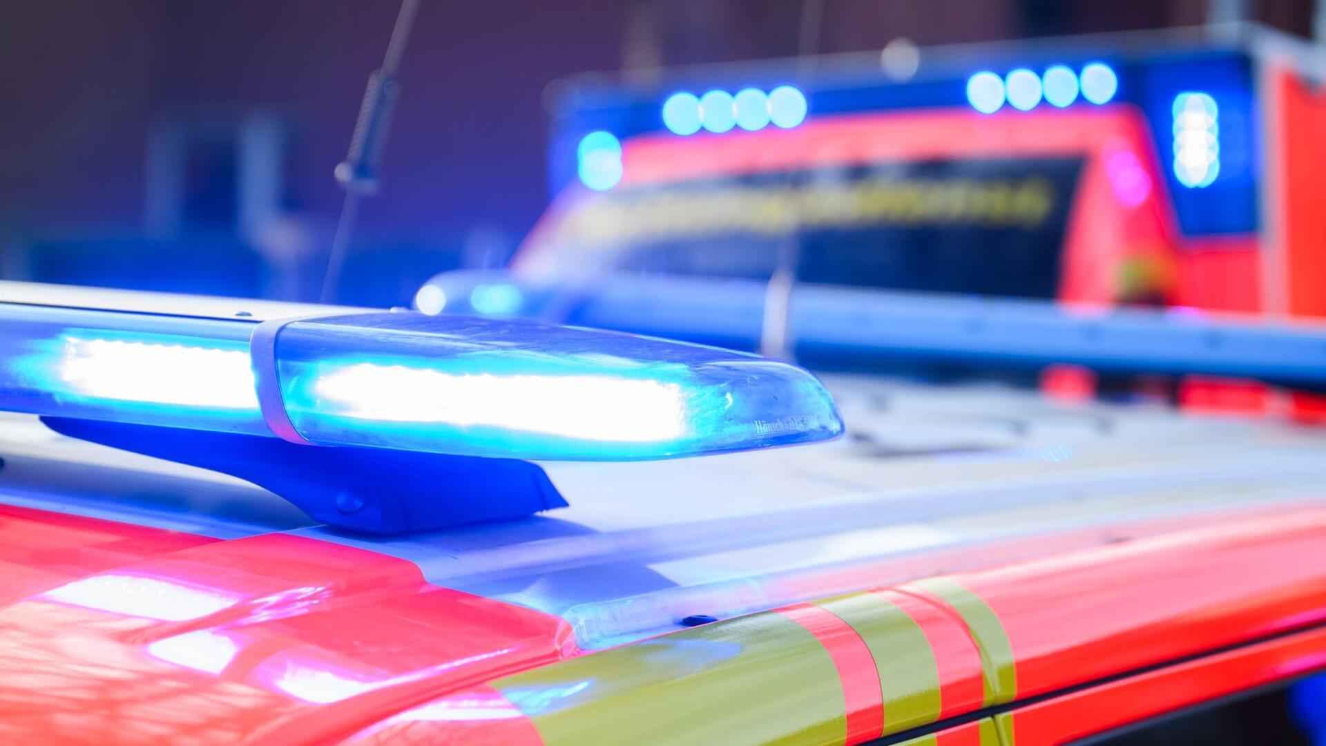 Blaulichter leuchten an einer Einsatzstelle auf einem Notarzt-Fahrzeug und einem Rettungswagen.