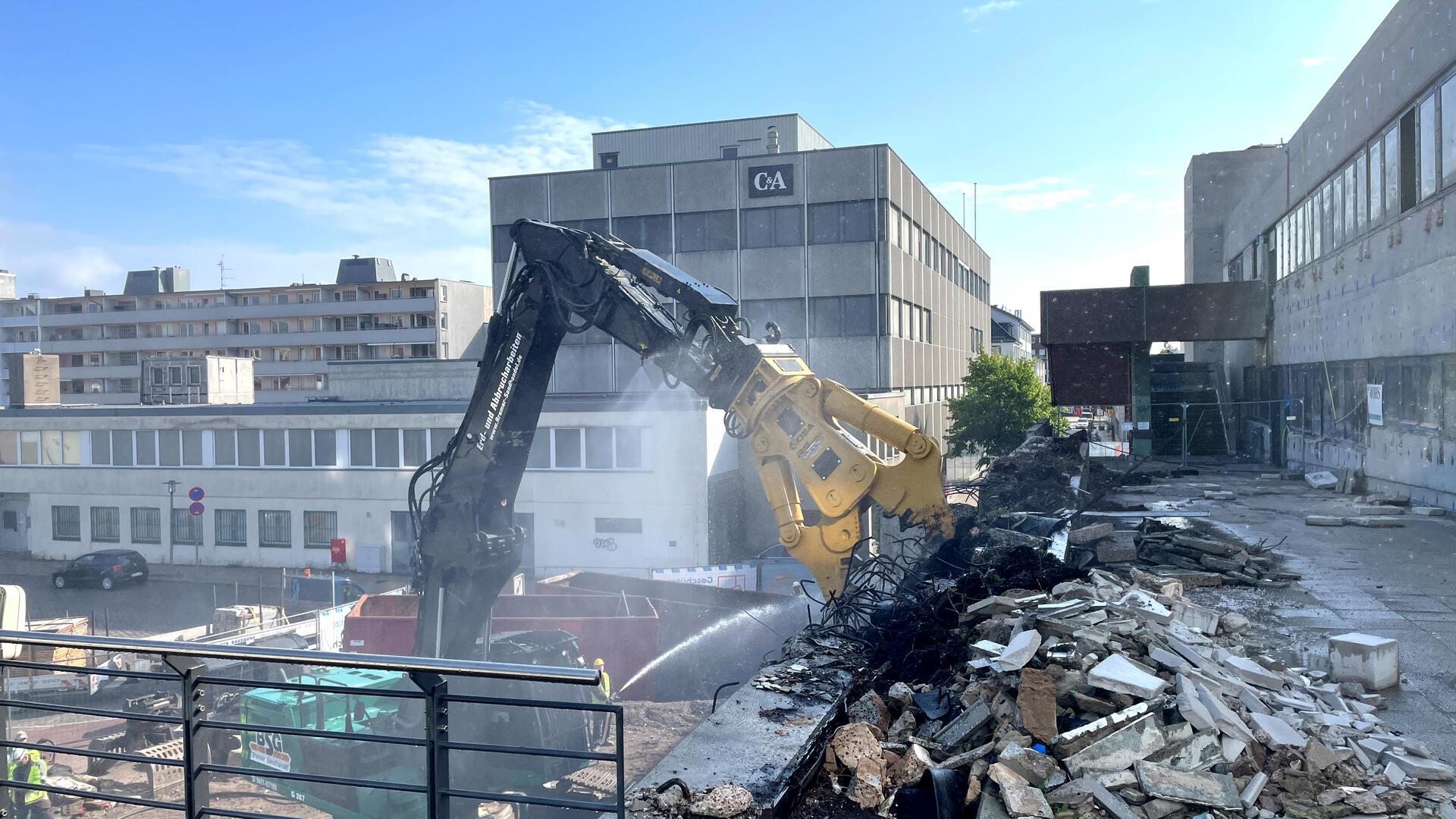 Ein Bagger reißt das Karstadtgebäude ein.