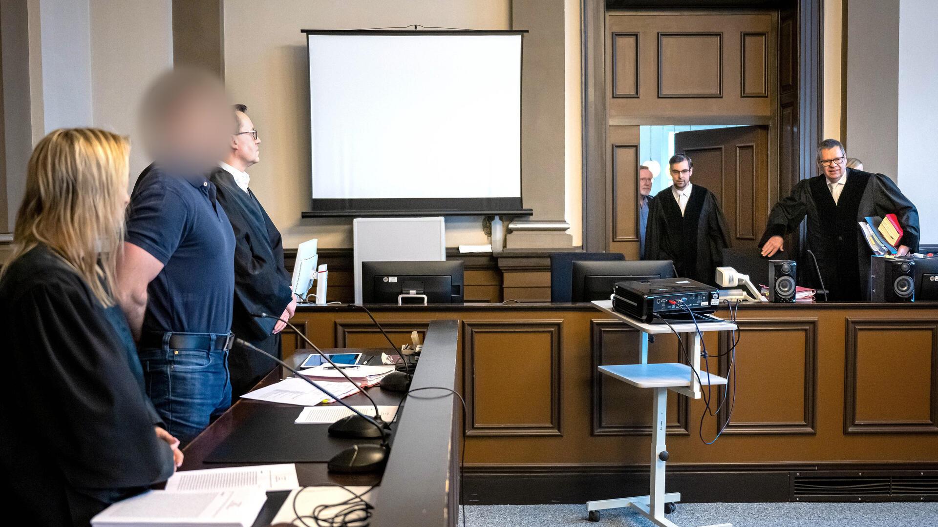 Der Angeklagte Florian G. steht neben seinen Verteidigern Daniela Post und René Lancker vor dem Vorsitzenden Richter Volker Stronczyk im Gerichtssaal vom Landgericht Verden. Der Mann soll vier Menschen aus dem Umfeld seiner damaligen Ehefrau erschossen haben.
