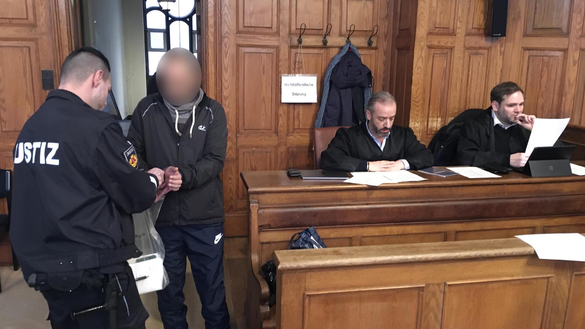 Justizbeamter löst Handschellen des Angeklagten. 
