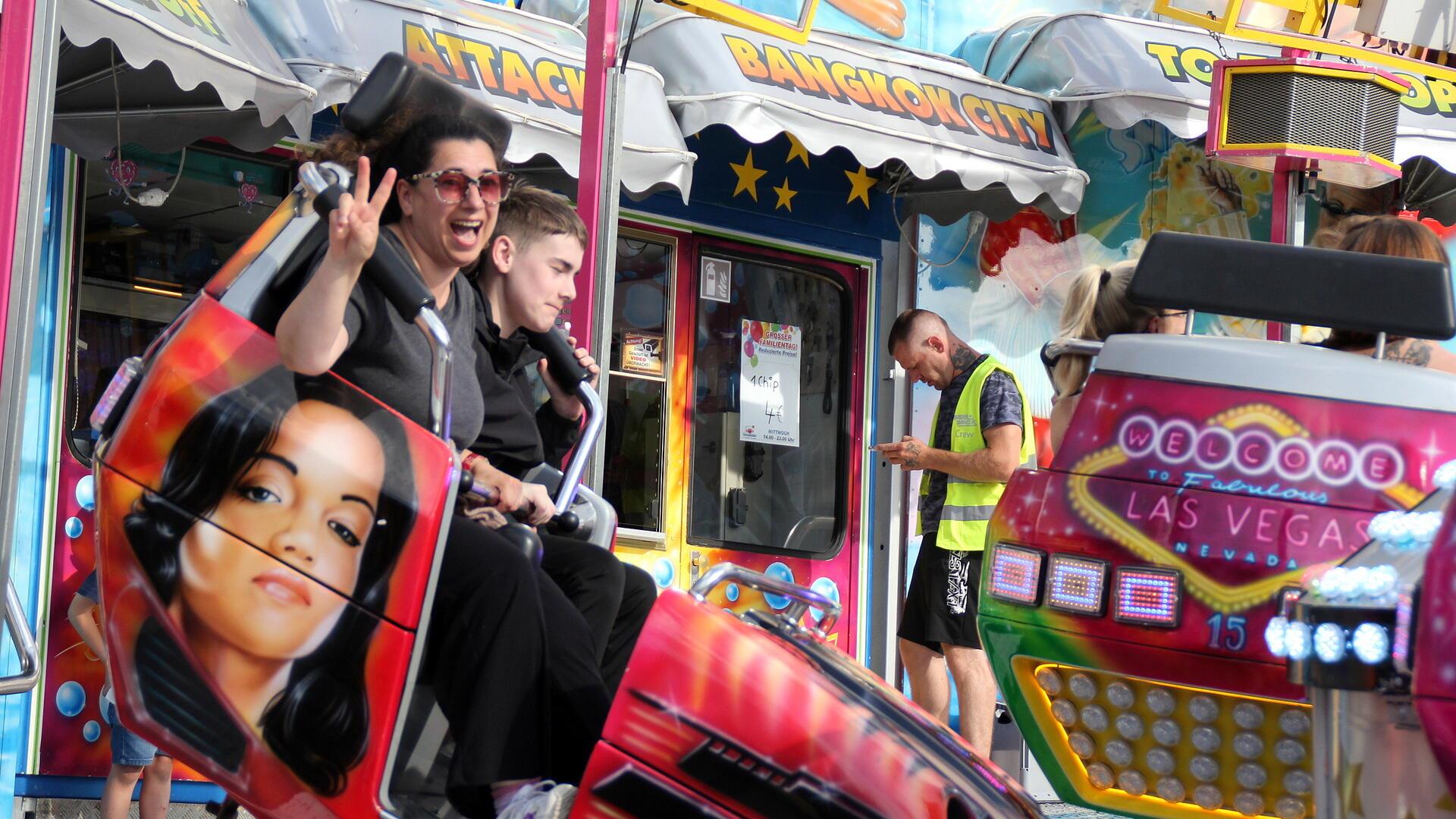Zwei Menschen in einem Fahrgeschäft auf dem Freimarkt. 