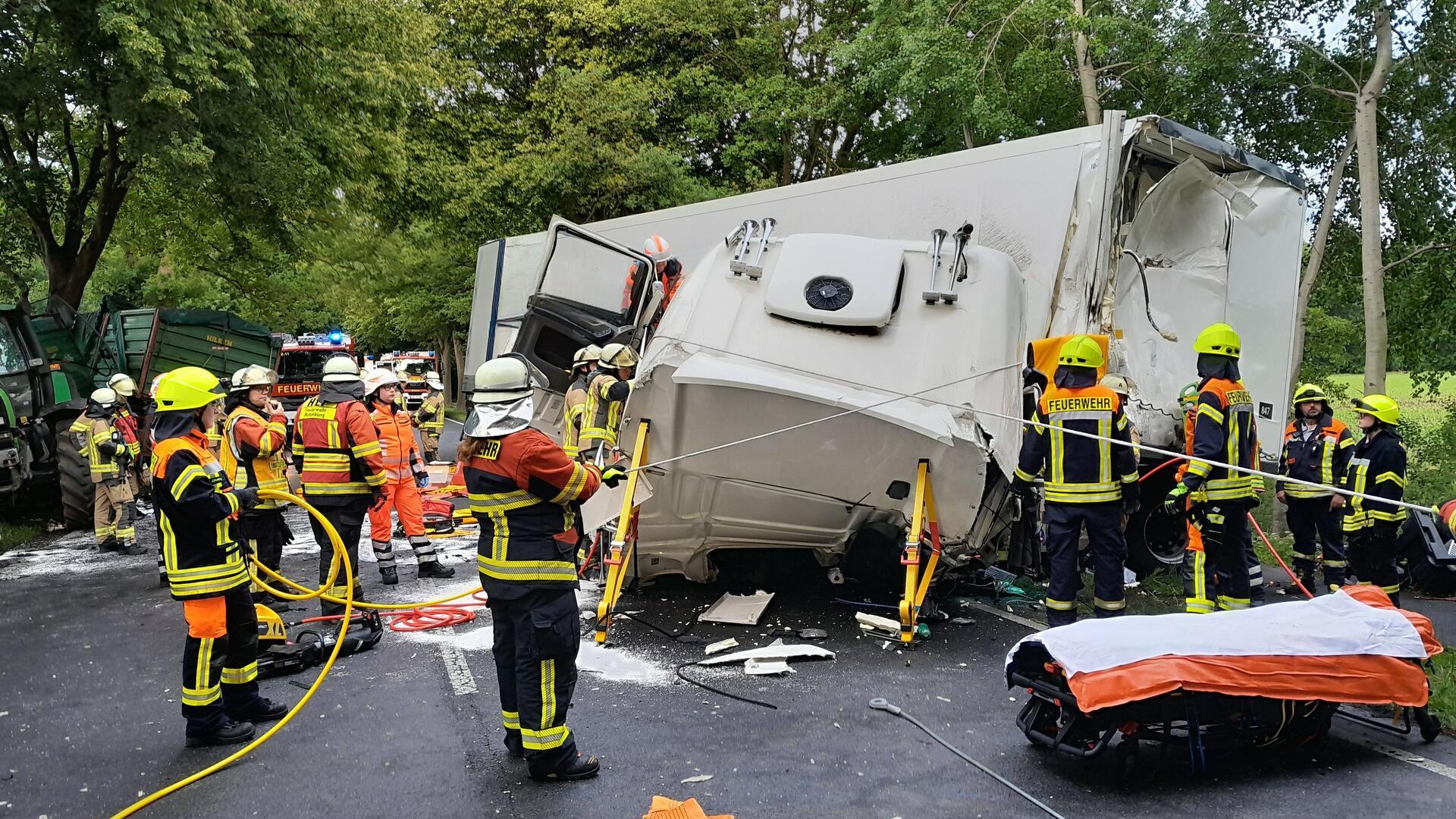 Einsatzkräfte stehen vor einem verunfallten Lkw. Der Fahrer dieses Lkw wurde in seinem Führerhaus eingeklemmt.