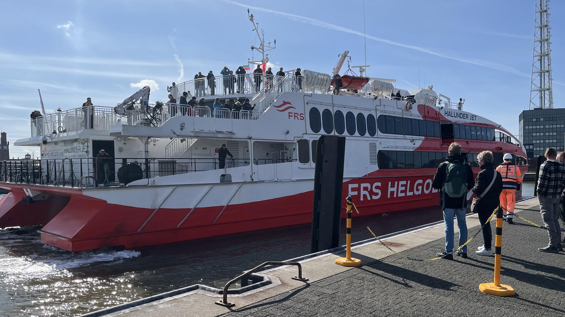 Blick auf ein Schiff, das anlegt. Der Halunder Jet bringt Touristen nach Helgoland. Wir haben ihn getestet und zeigen sieben Unterschiede zur Fahrt mit dem Seebäderschiff.