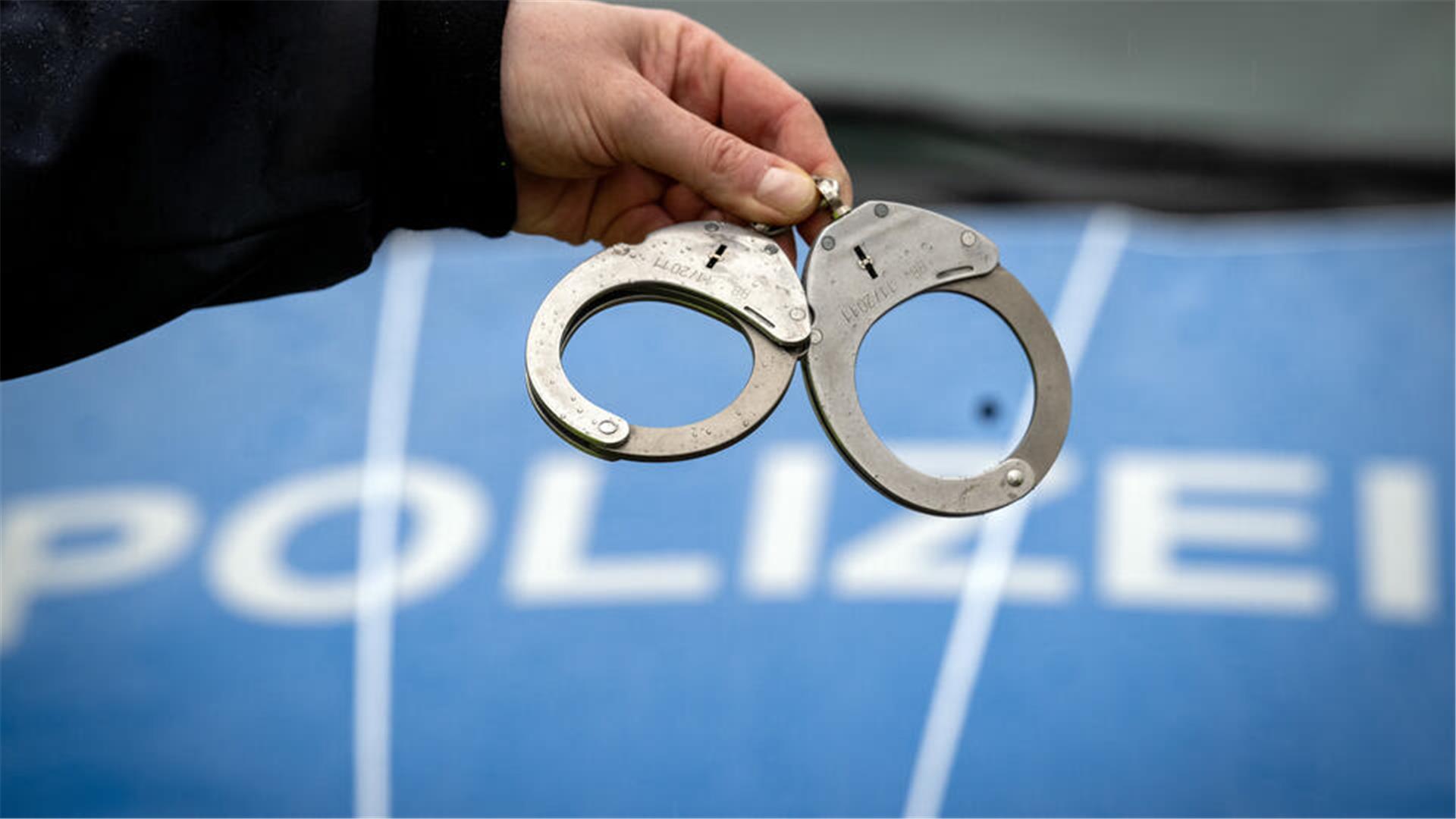 Handschellen und ein Polizeifahrzeug