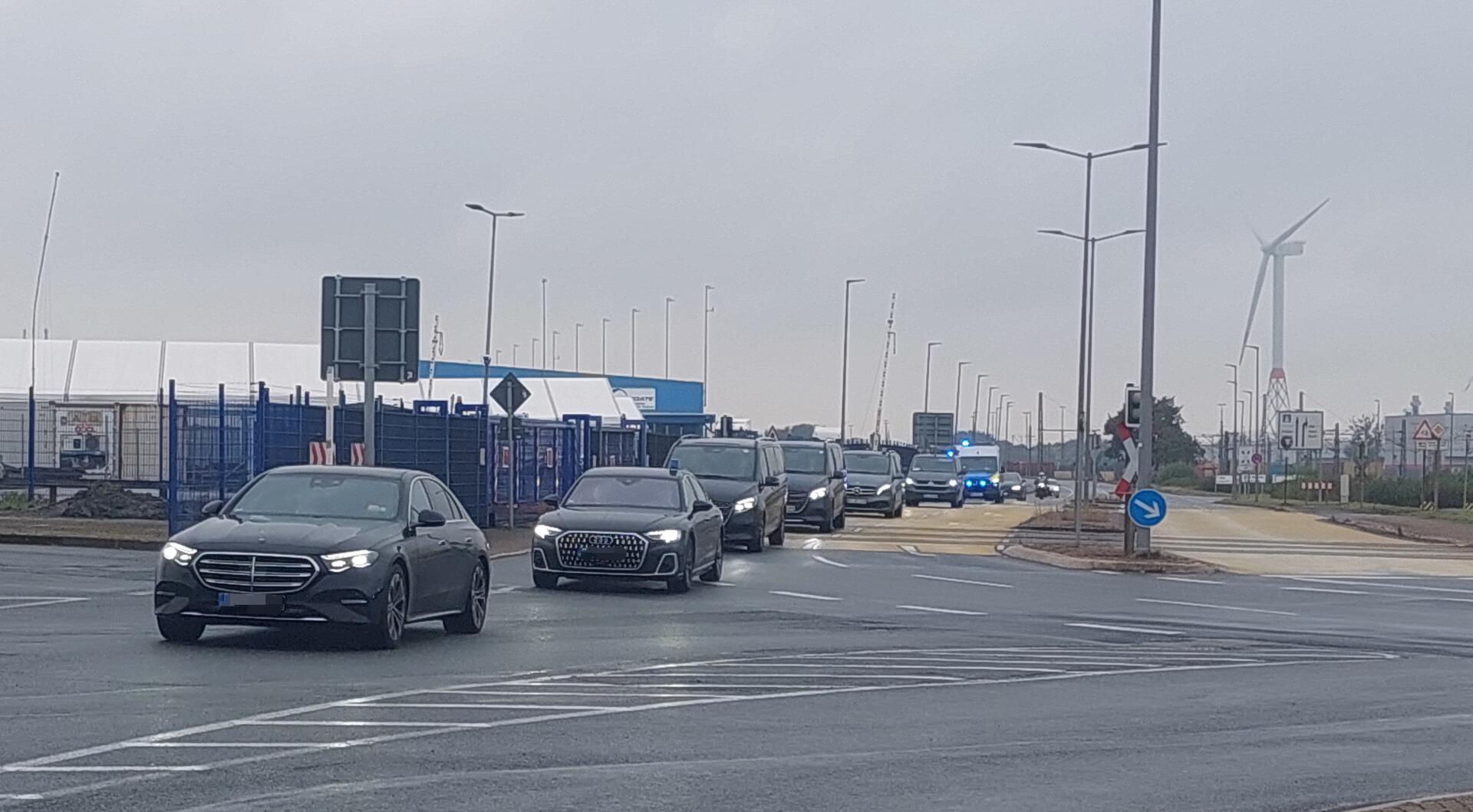 Eine Autokolonne aus schwarzen Autos und Polizeiwagen.