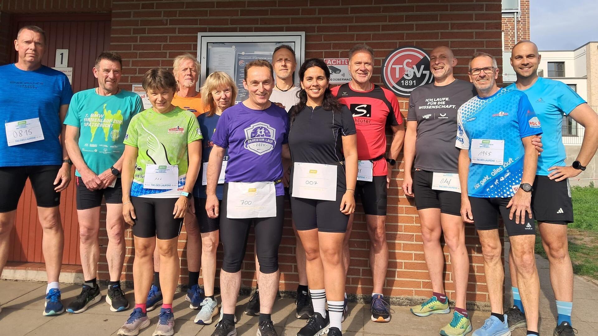 Männer und Frauen in Sporttrikots stehen nebeneinander.