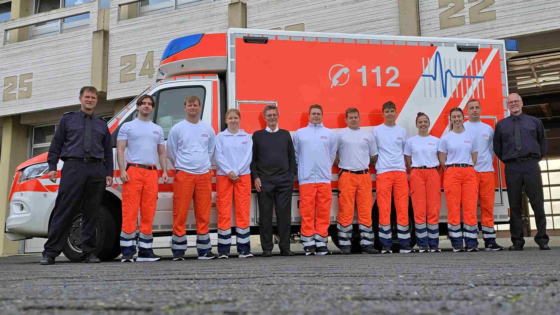 Menschen stehen vor einem Rettungswagen