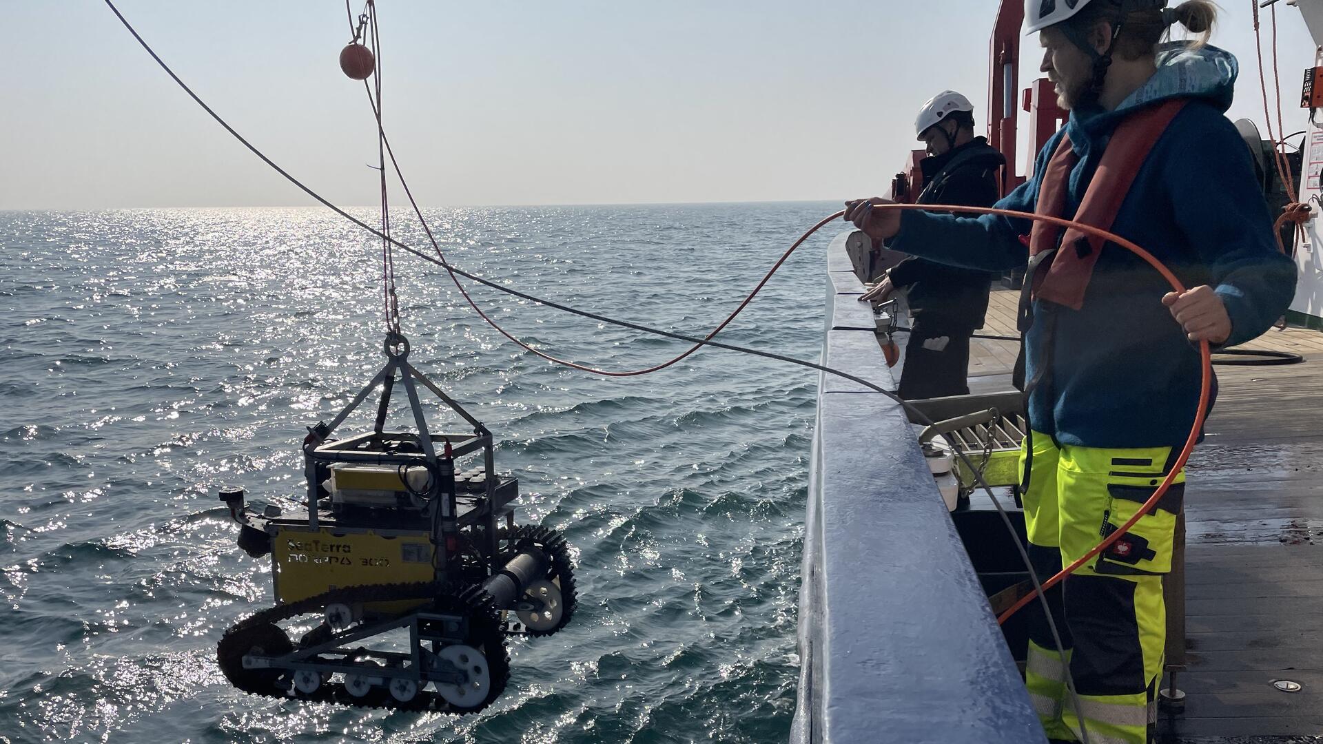 Ein Forschungsteam mit einem Roboter auf hoher See.