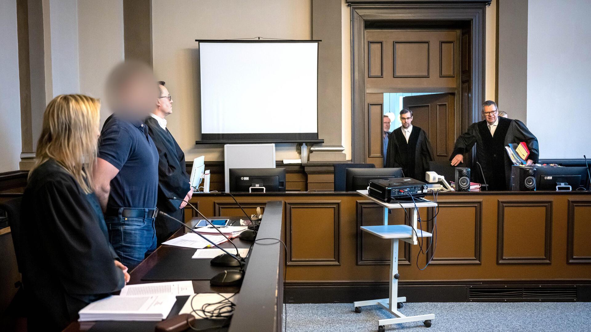  Der Angeklagte steht neben seinen Verteidigern Daniela Post (l) und René Lancker vor dem vorsitzenden Richter Volker Stronczyk (r) im Gerichtssaal vom Landgericht Verden. 