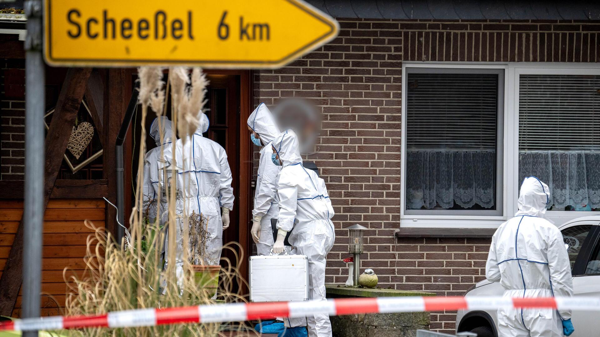Vier Männer in weißen Anzügen vor einem Haus.
