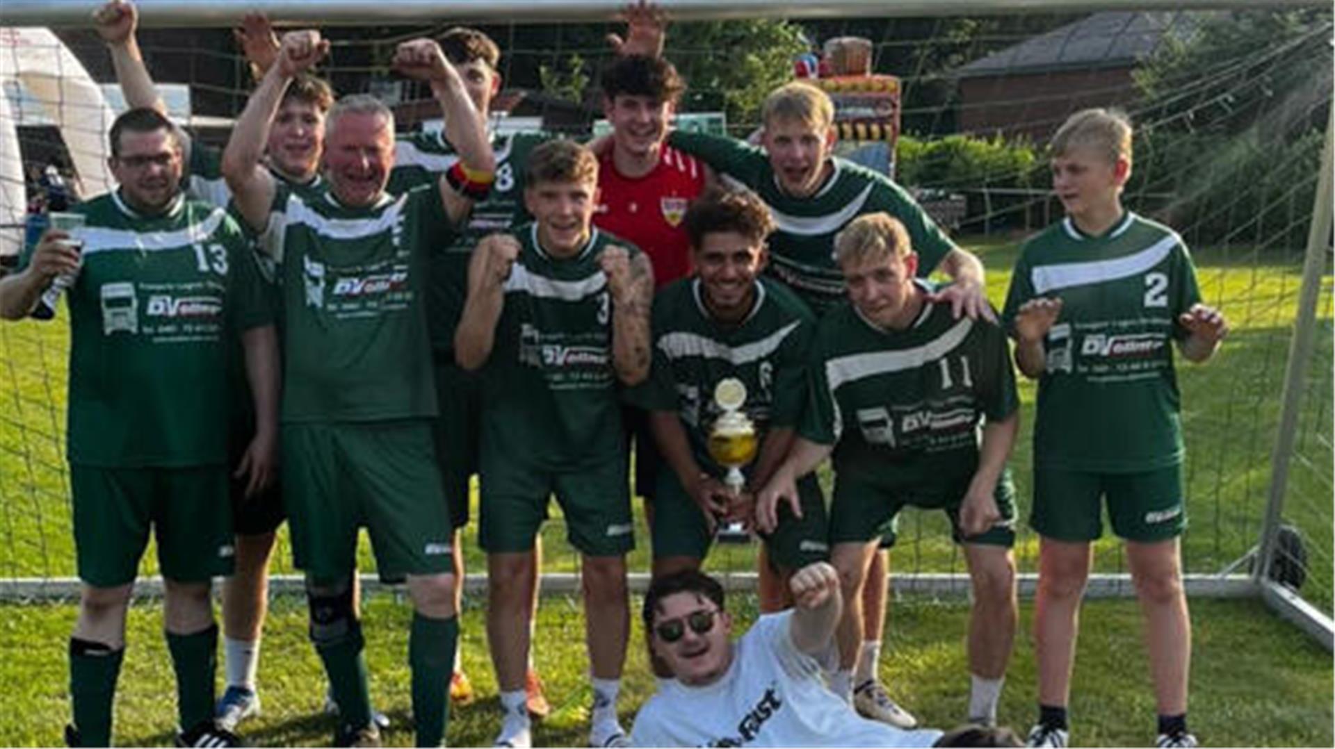 Ein Fußballteam steht im Fußballtor und jubelt.