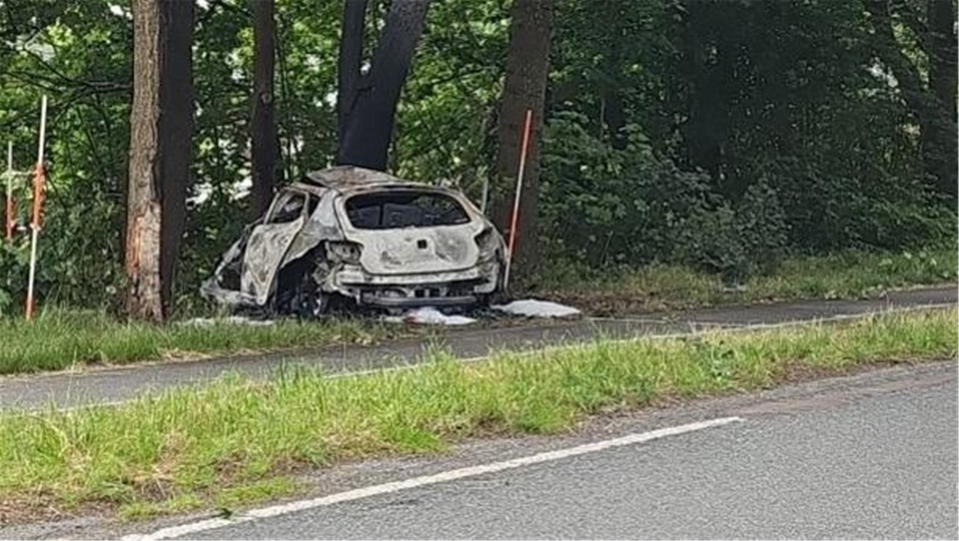 Ein Auto steht nach einer Kollision zerstört im Seitenrand einer Straße.