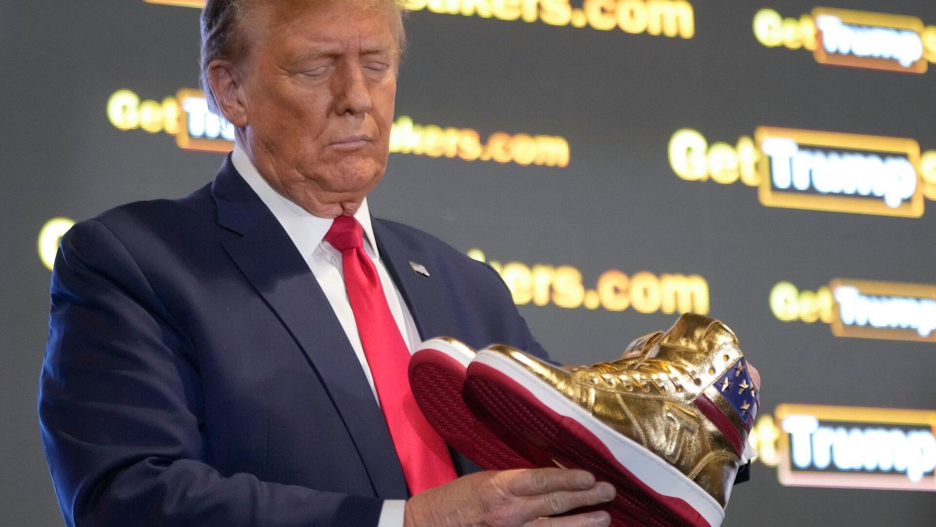 Bilder des Tages Der ehemalige US-Präsident Donald Trump hält goldene Trump-Sneakers auf der Sneaker Con Philadelphia, einer Veranstaltung für Sneakersammler.