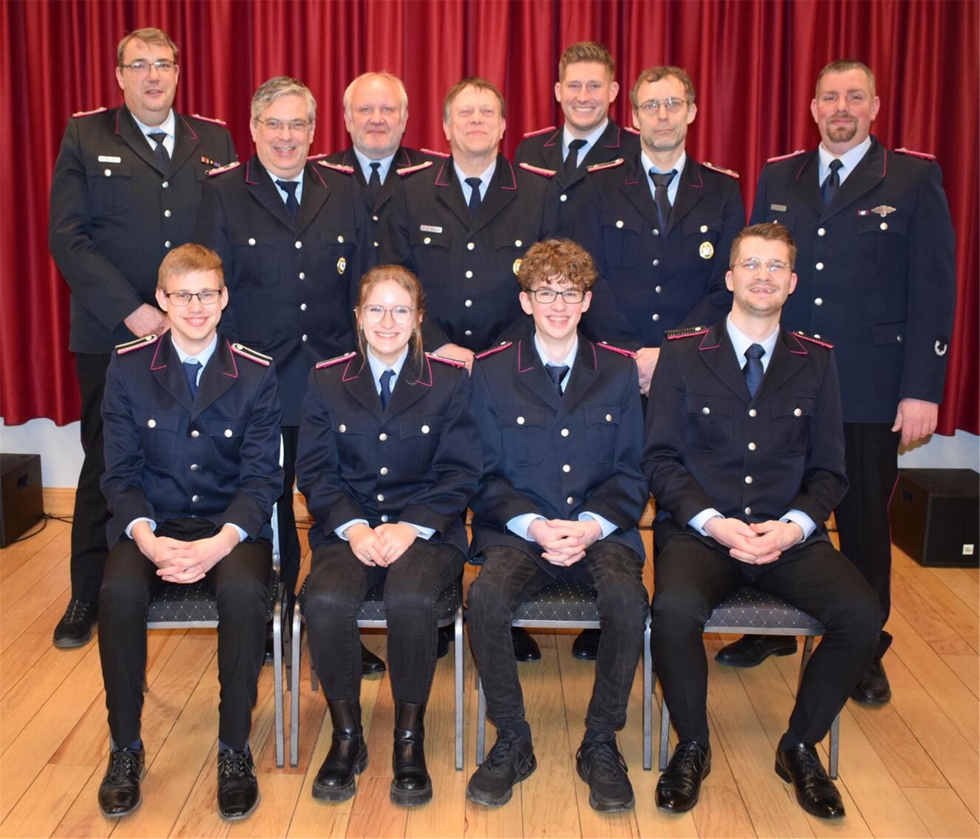 Der erste stellvertretende Stadtbrandmeister Martin Borchers (hinten links) und Ortsbrandmeister Carsten Sumpf (hinten rechts) mit den geehrten, beförderten oder neu in Positionen gewählten Mitgliedern der Ortsfeuerwehr.
