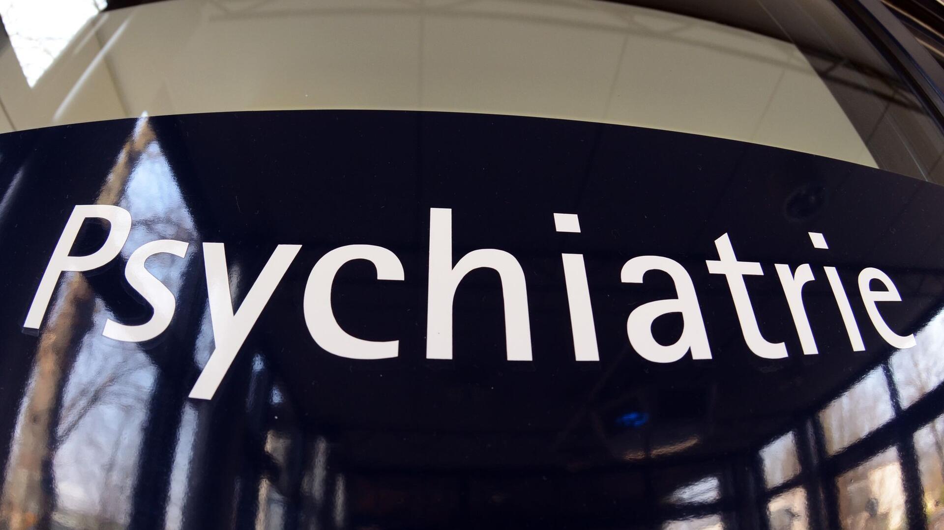 Ein Schild mit der Aufschrift "Psychiatrie" an einem Gebäude. 