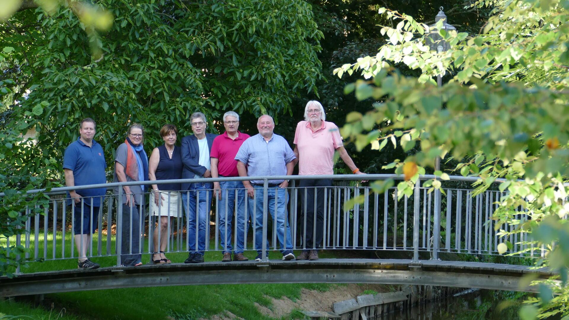 7 ältere Leute auf einer Brücke
