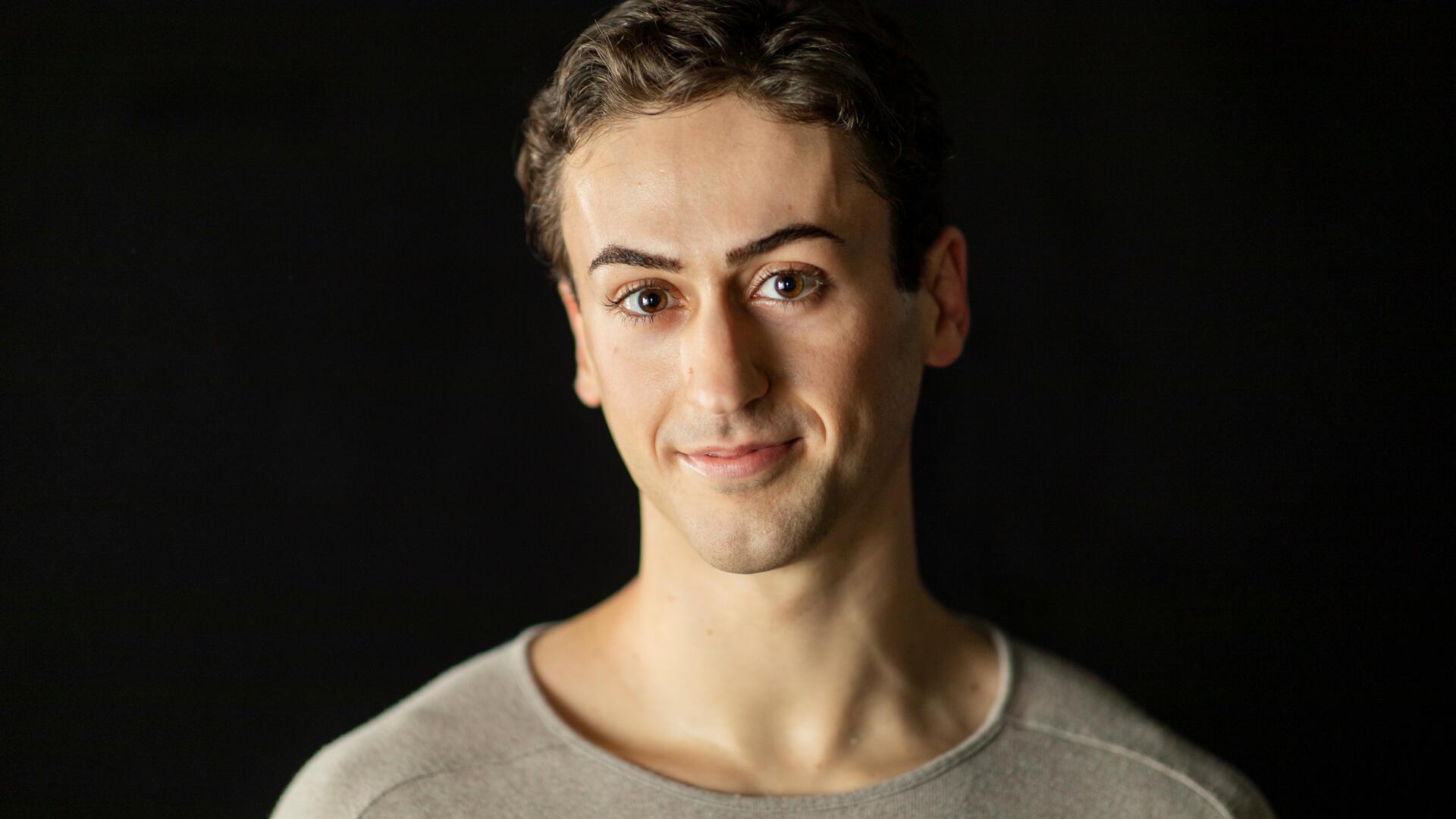 Ein Mann mit kurzen Haaren und dunklen Augen.