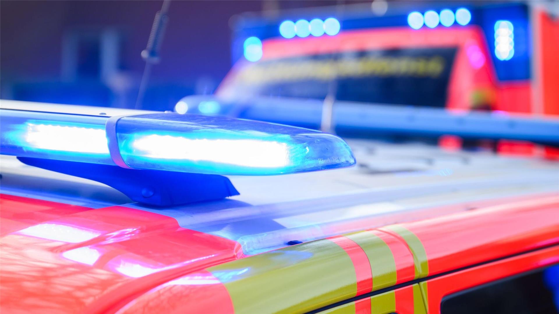 Blaulichter leuchten an einer Einsatzstelle auf einem Notarzt-Fahrzeug und einem Rettungswagen.