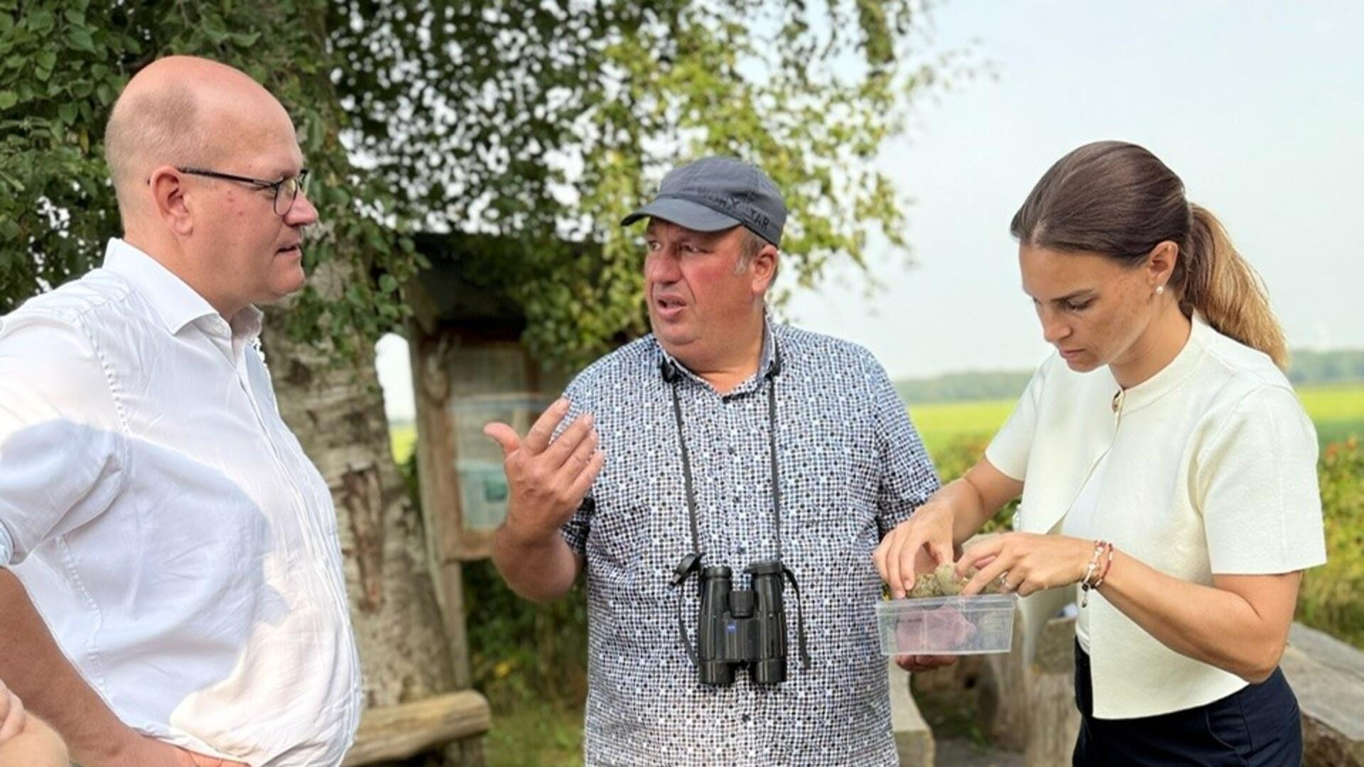 Detlef Ertel, Mitarbeiter des Wiesenvogelprojektes, erläutert Dr. Marco Mohrmann die Bedeutung des Wiesenvogelschutzes. Vanessa Zobel betrachtet die mitgebrachten Brachvogel-Eischalen. 