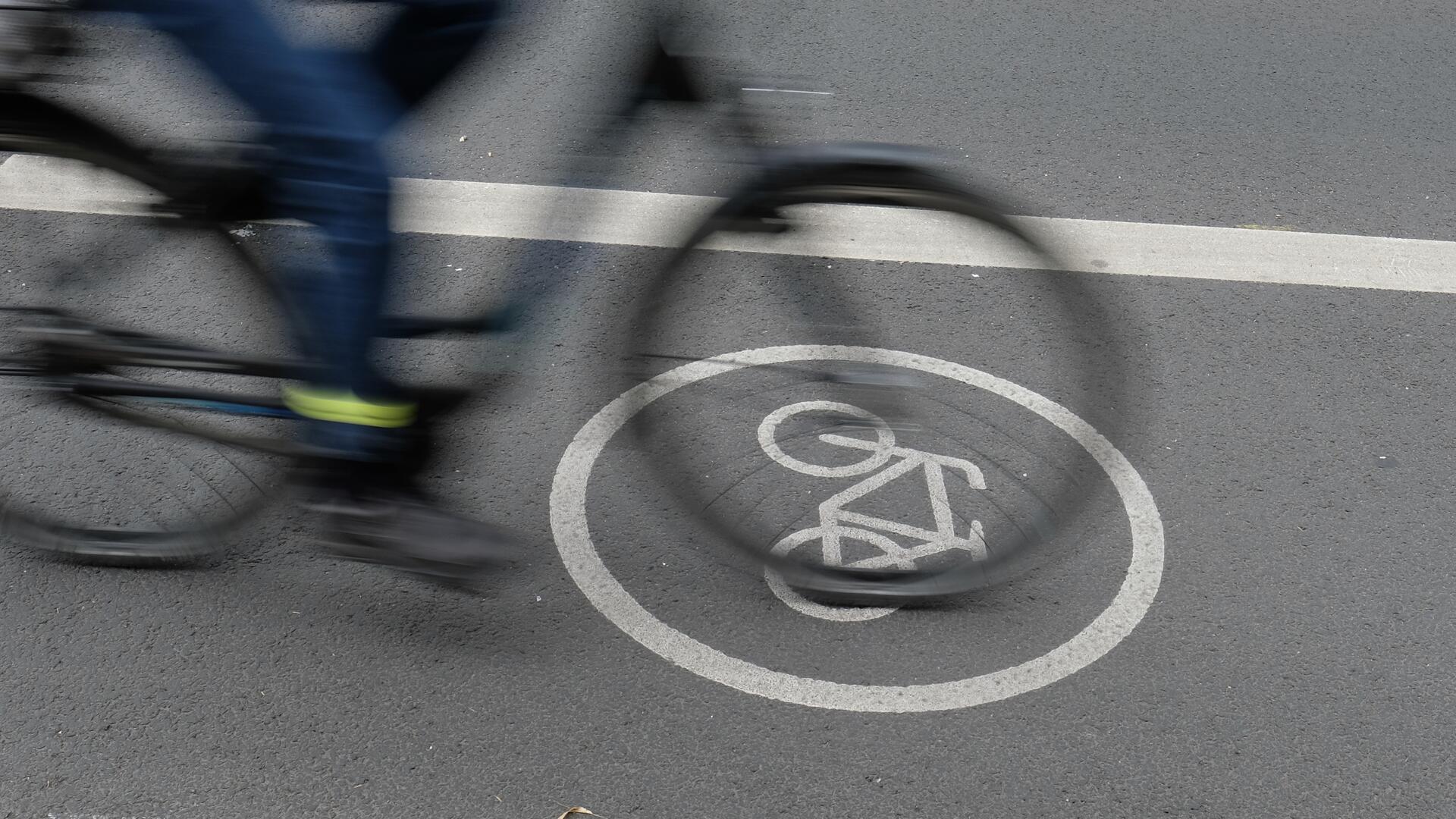 Ein Fahrradweg, auf dem ein Rad mit Person darauf im Vorbeifahren fotografiert wurde.