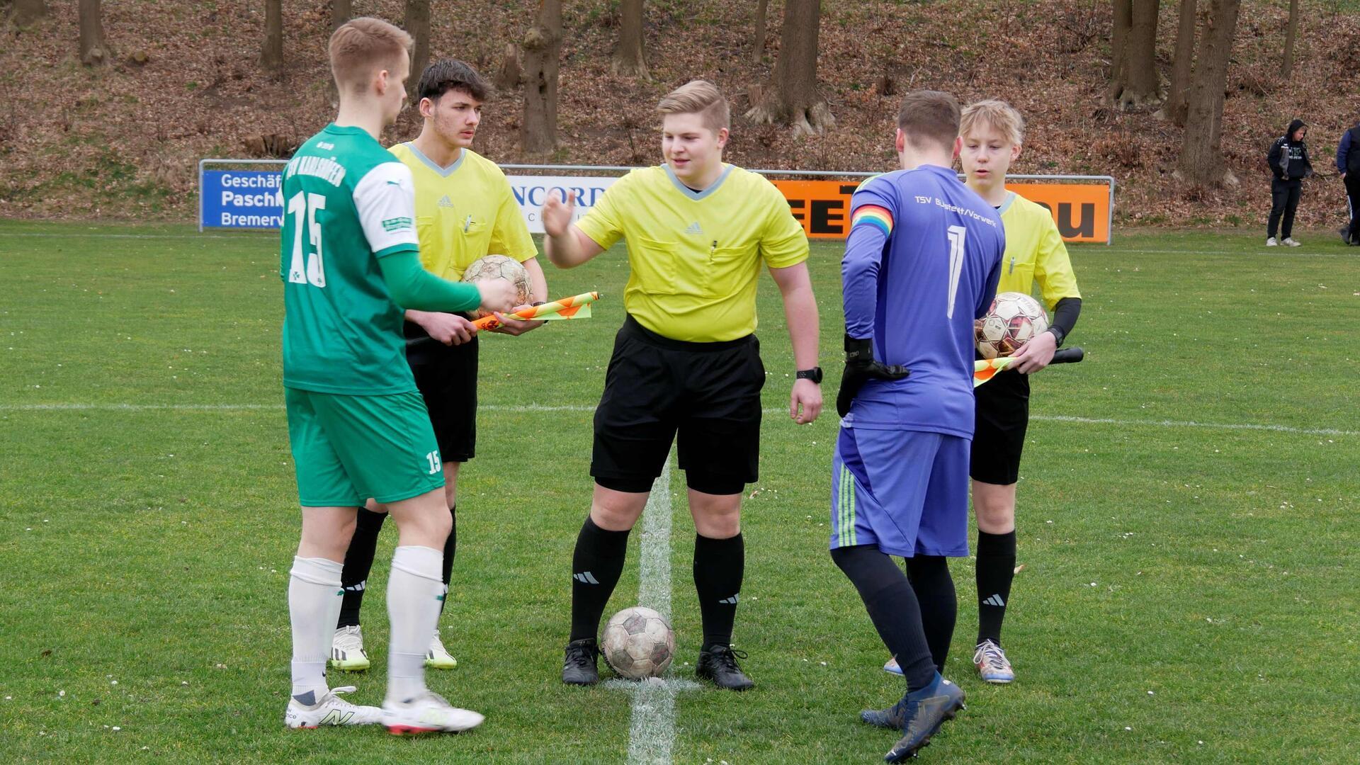 Die Assistenten Tetje Hausschild und Justin Sieling sowie Schiedsrichter Jonte Martens (Mitte) begrüßen die Kapitäne vom TSV Karlshöfen und TSV Bülstedt/ Vorwerk.