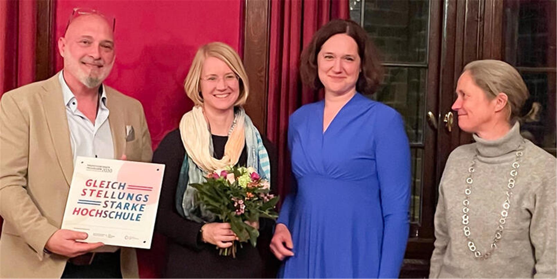 Ein Mann (links) und drei Frauen bei einer Feierstunde im Bremer Rathaus. Übergeben worden ist eine Auszeichnung. 