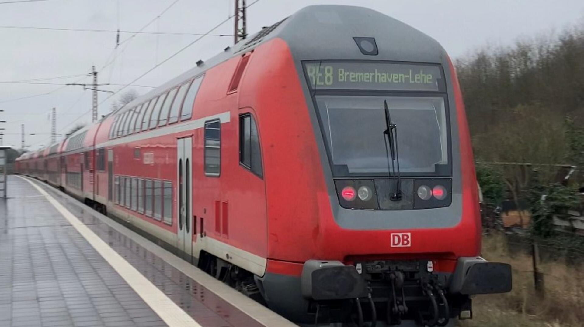 Symbolbild Bahnstrecke Bremerhaven–Bremen gesperrt: Eine Bahn hält am Bahnhof, an dem Menschen warten. 