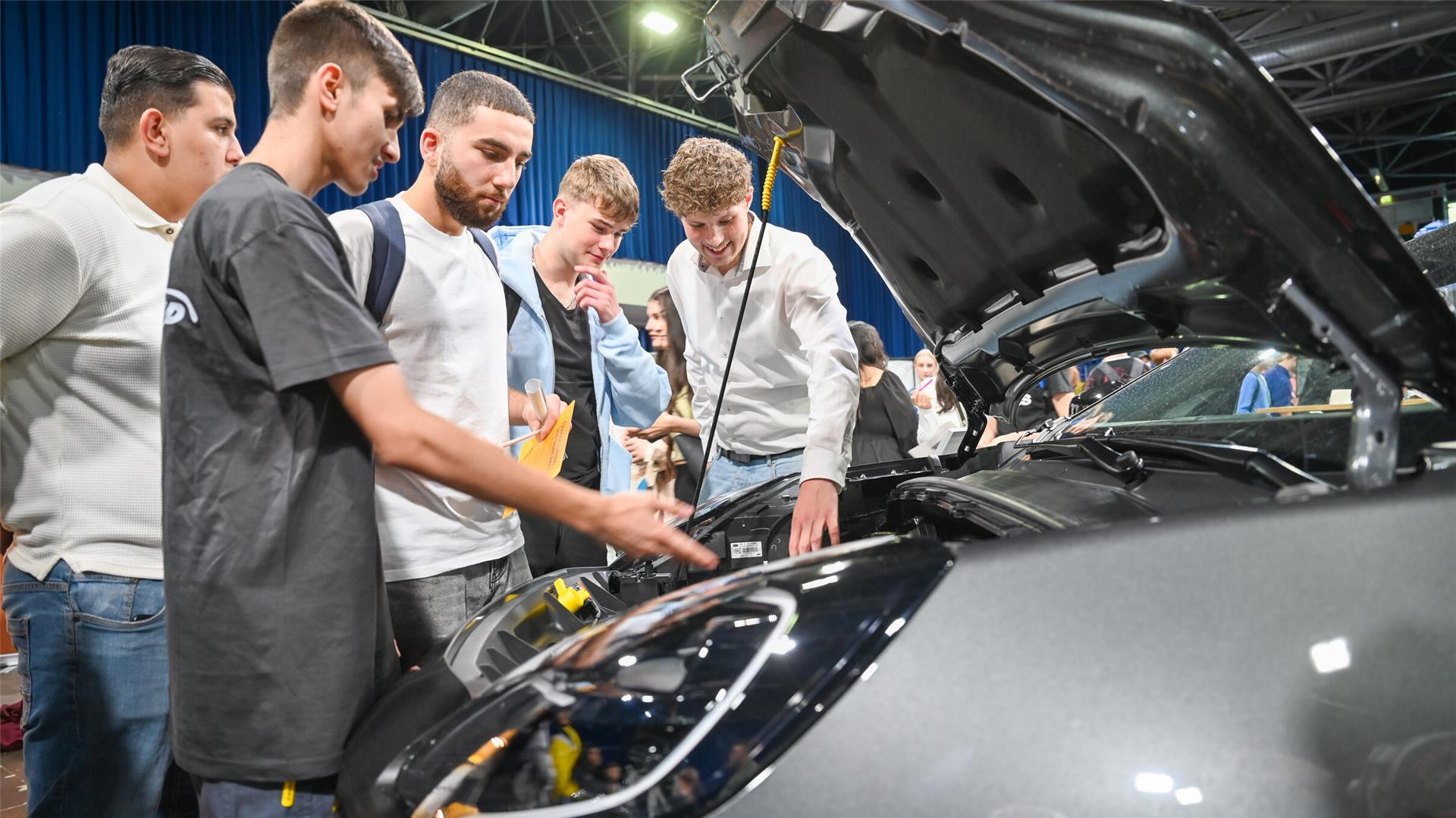 Junge Menschen schauen in das Innere eines Autos. 