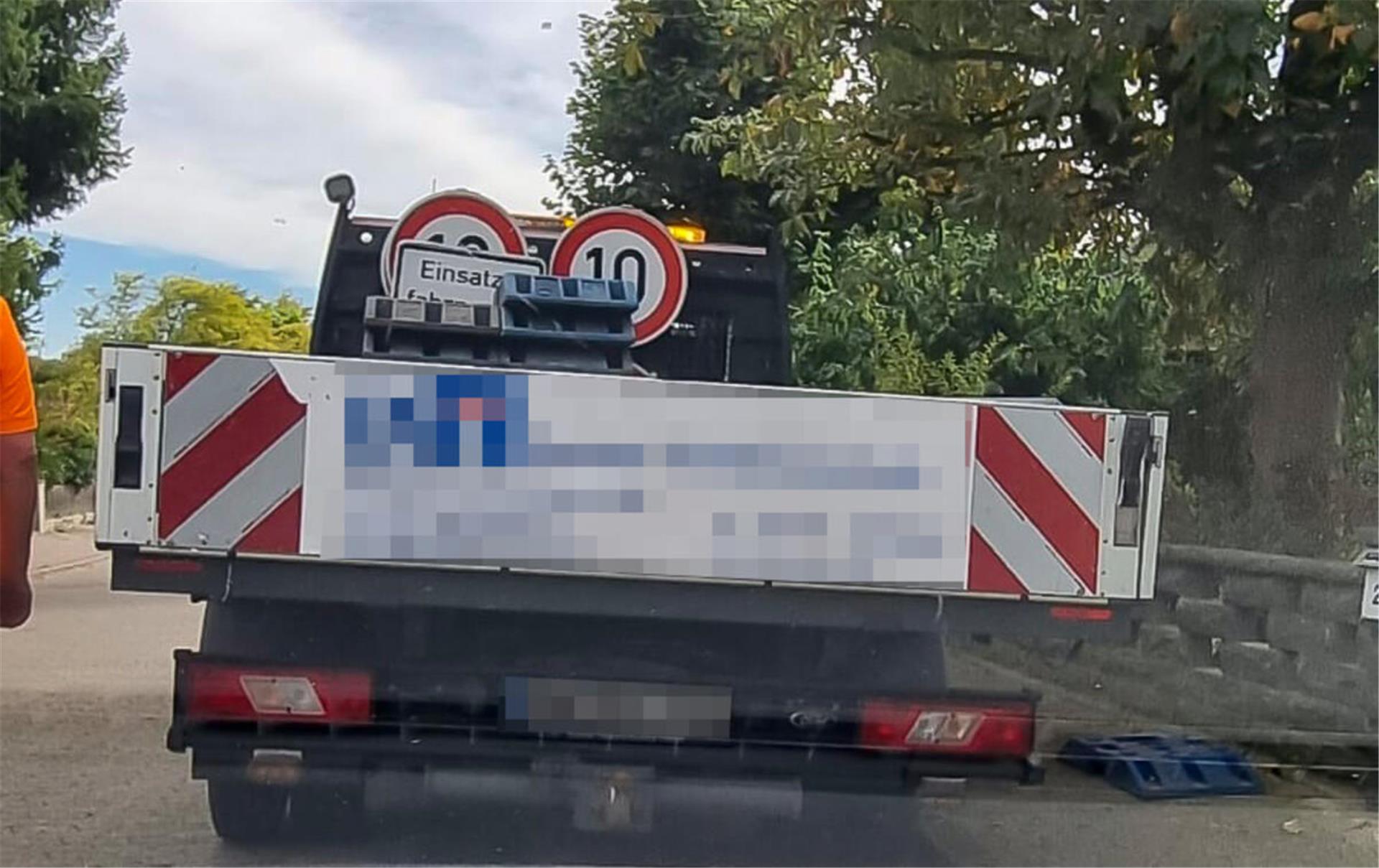 Ein Wagen mit Auflage, auf der Straßenschilder stehen und liegen.