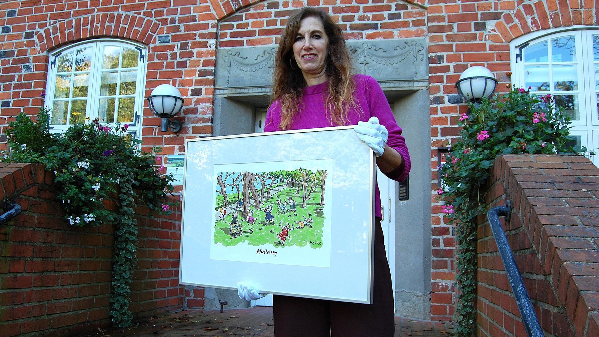 Eine Frau hält einen Cartoon in einem Bilderrahmen hoch.