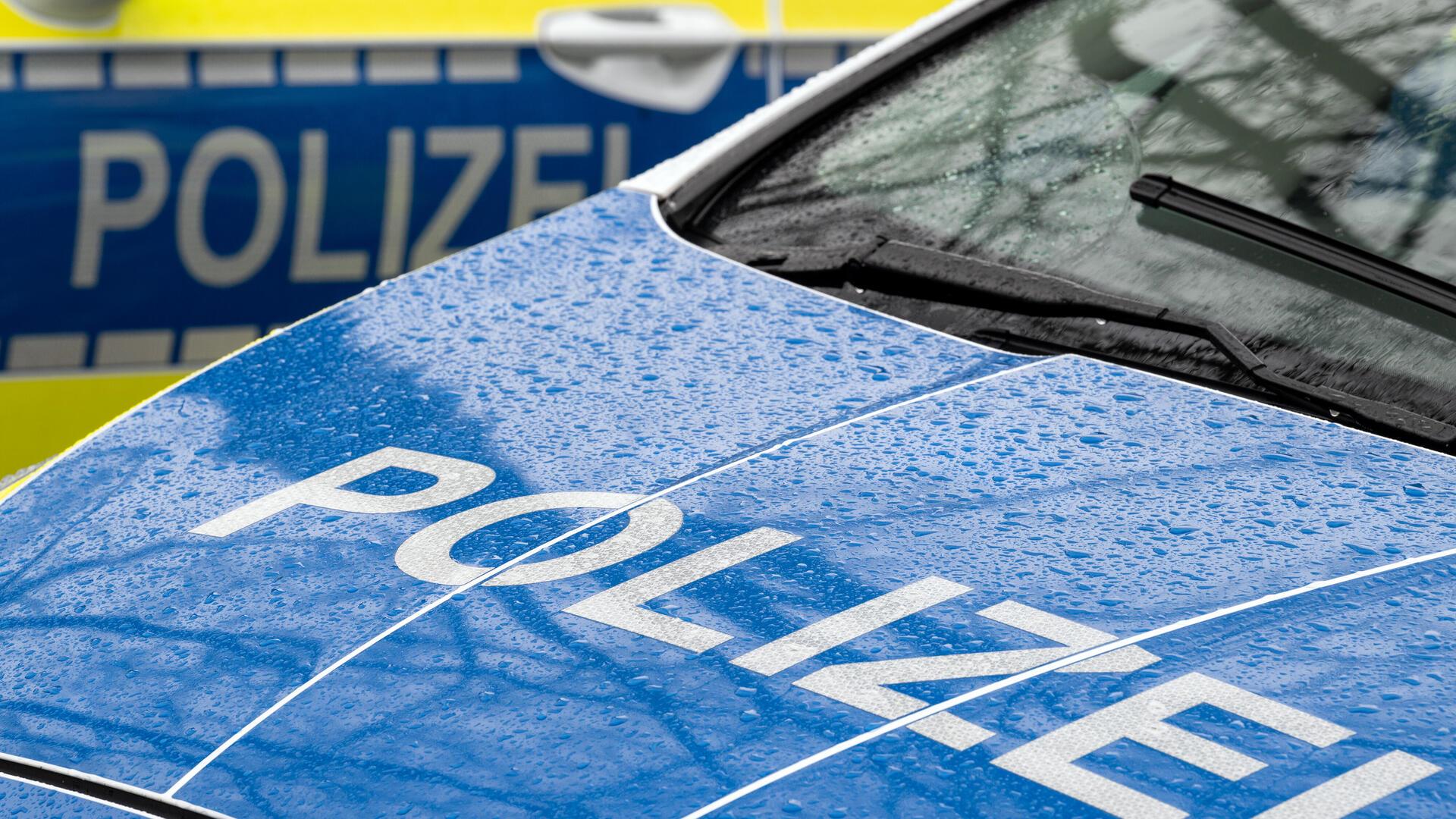 Der Schriftzug „Polizei“ ist auf der Kühlerhaube eines Autos zu lesen 