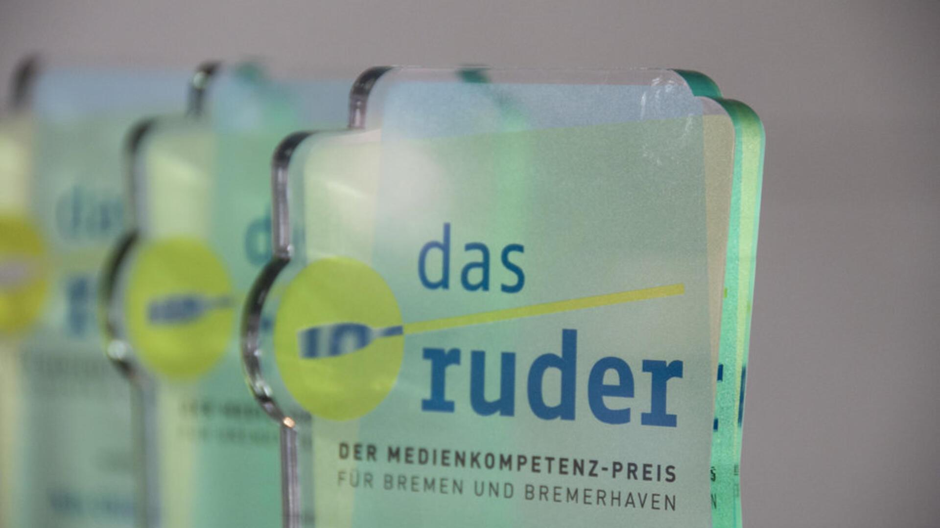 Ein gläserner Pokal mit der Aufschrift "das ruder" steht auf einem Tisch. Die Bremische Landesmedienanstalt verleiht in diesem Jahr erneut den Medienkompetenzpreis „das ruder“.